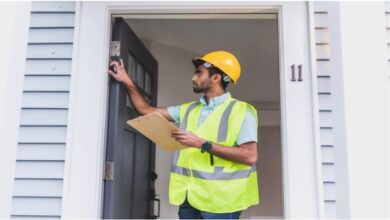 A man in construction safety gear inspecting a front door