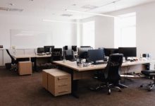 Professional office interior with glass partitions, conference table, and neutral color theme.